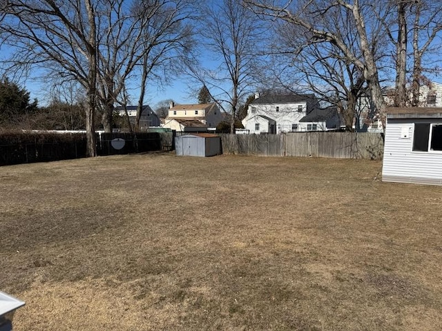 view of yard featuring a fenced backyard, an outdoor structure, and a storage shed