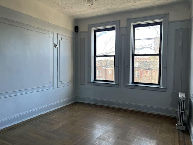 empty room with baseboards and a textured ceiling