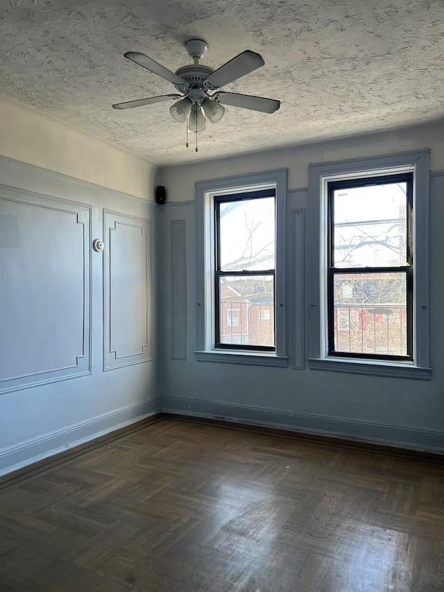 spare room with a ceiling fan, baseboards, and a textured ceiling