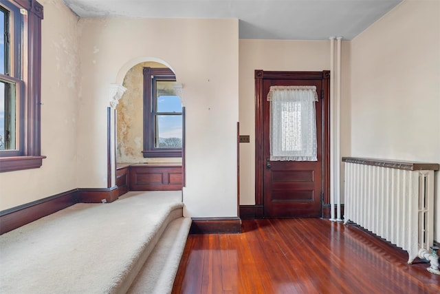 entrance foyer with baseboards, hardwood / wood-style floors, and radiator