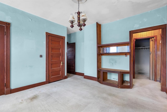 interior space featuring baseboards, a closet, carpet flooring, and a notable chandelier