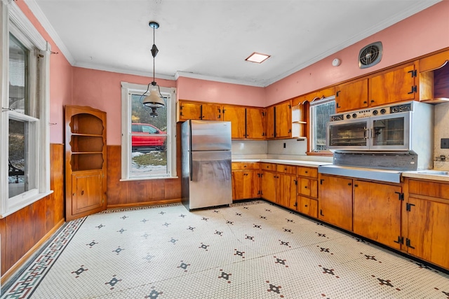 kitchen with appliances with stainless steel finishes, brown cabinets, and light countertops