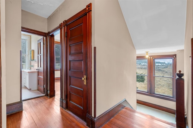 hall featuring baseboards and hardwood / wood-style flooring