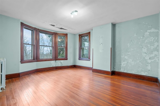 empty room featuring wood-type flooring and baseboards