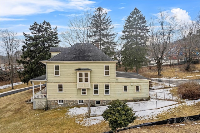 view of property exterior with a yard, roof with shingles, fence, and a chimney