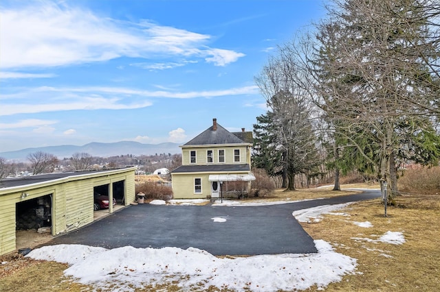 view of front facade with a garage, an outdoor structure, and a mountain view