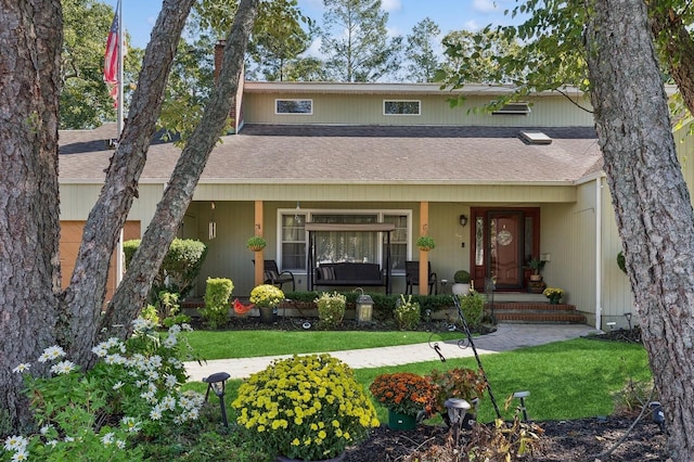 view of front of home featuring a porch, roof with shingles, and a front lawn