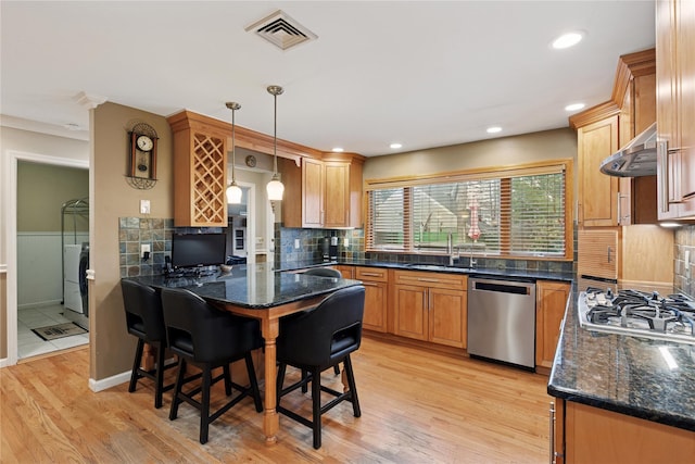 kitchen with appliances with stainless steel finishes, visible vents, under cabinet range hood, and light wood finished floors