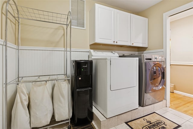 laundry area featuring visible vents, cabinet space, washer and clothes dryer, and light tile patterned floors