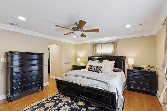 bedroom featuring ornamental molding, visible vents, and wood finished floors