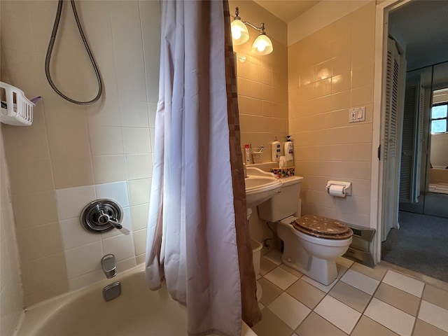 full bath featuring toilet, tile patterned flooring, shower / bath combo, and tile walls