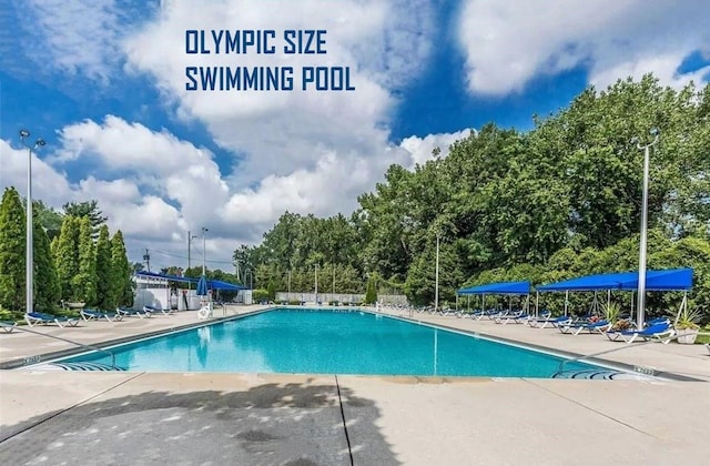 community pool with a patio area and fence