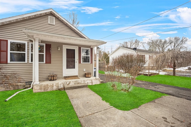 bungalow-style house featuring covered porch and a front yard