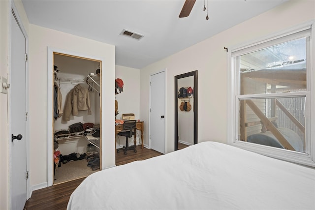 bedroom with ceiling fan, visible vents, and dark wood-style flooring