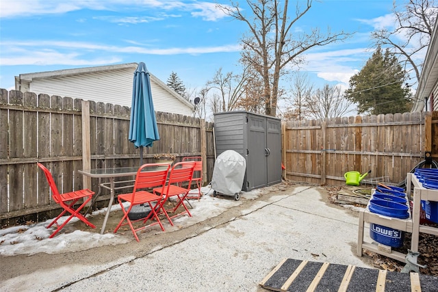 view of patio with a storage shed, an outdoor structure, and a fenced backyard