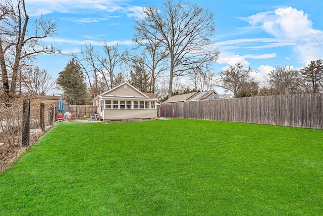 view of yard featuring a sunroom and a fenced backyard