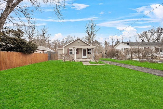 rear view of house featuring a yard, aphalt driveway, and fence