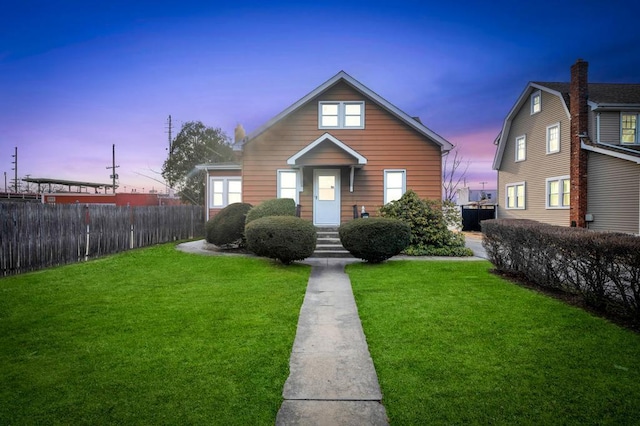 bungalow featuring a front yard and fence