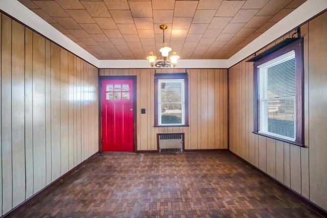 entryway featuring a chandelier, radiator, a healthy amount of sunlight, and baseboards