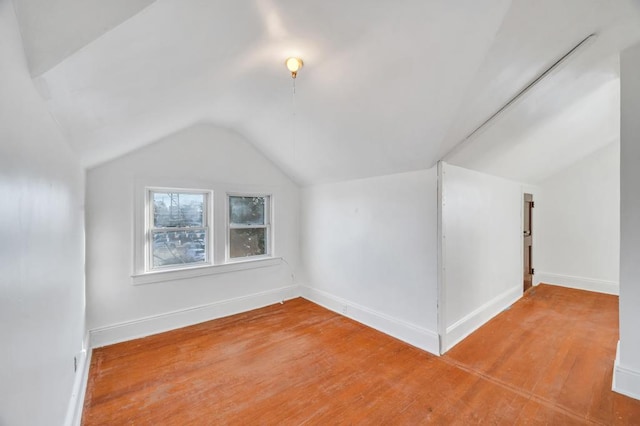 bonus room featuring vaulted ceiling, light wood-type flooring, and baseboards