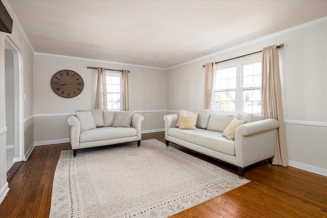 living room with crown molding, baseboards, and wood finished floors