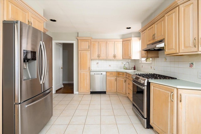 kitchen with stainless steel appliances, light brown cabinets, light countertops, and under cabinet range hood