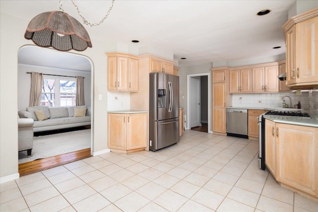 kitchen featuring appliances with stainless steel finishes, light countertops, decorative backsplash, and light brown cabinetry