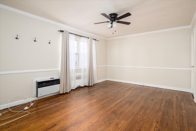 spare room with a ceiling fan, crown molding, baseboards, and wood finished floors