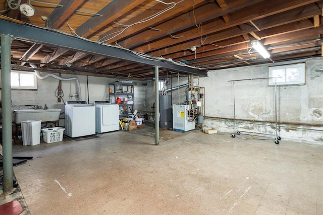 below grade area featuring water heater, a sink, washing machine and clothes dryer, and tile patterned floors