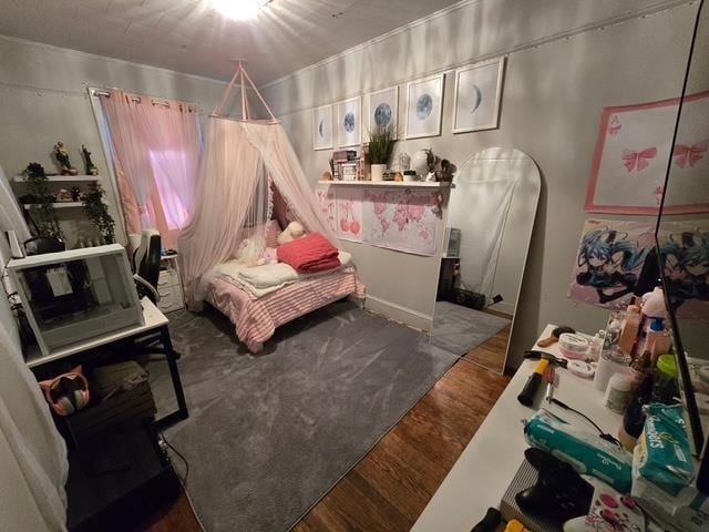 bedroom with arched walkways and wood finished floors