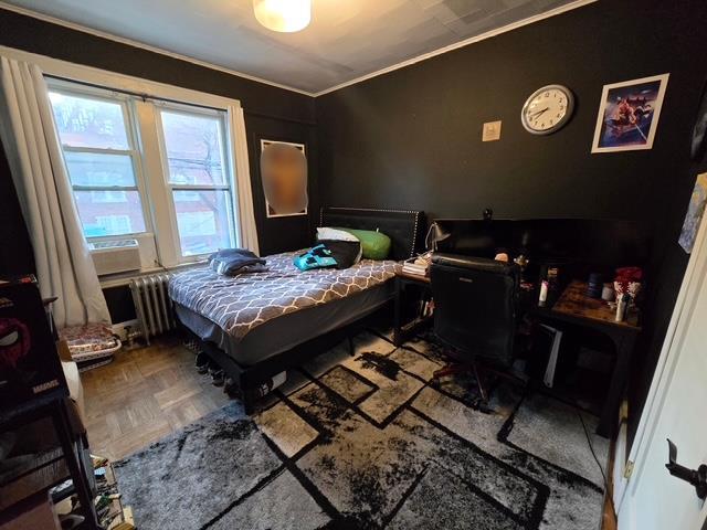 bedroom with radiator heating unit and crown molding