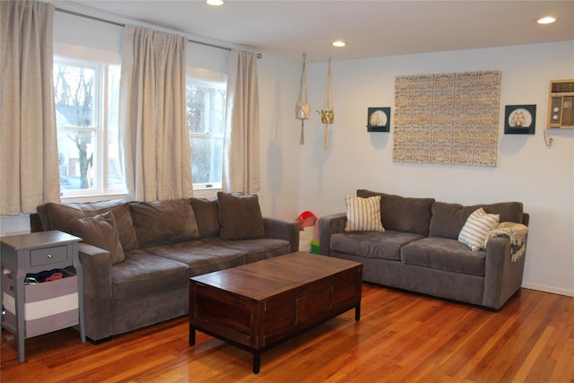 living area featuring recessed lighting, a wall mounted air conditioner, and wood finished floors