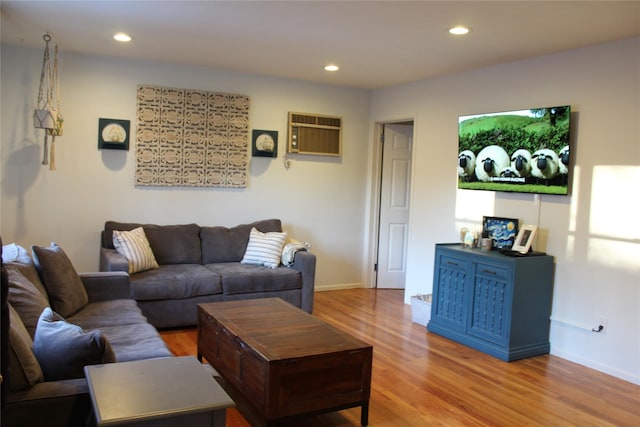 living room with baseboards, an AC wall unit, wood finished floors, and recessed lighting