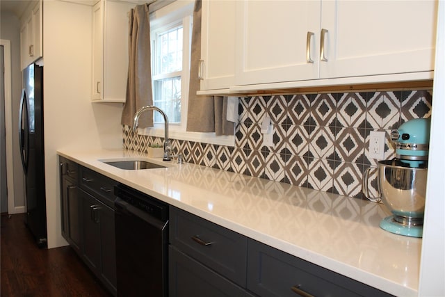 kitchen featuring tasteful backsplash, light countertops, white cabinetry, a sink, and black appliances