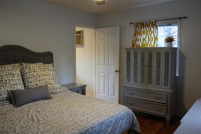 bedroom featuring a wall mounted air conditioner, dark wood finished floors, and ceiling fan