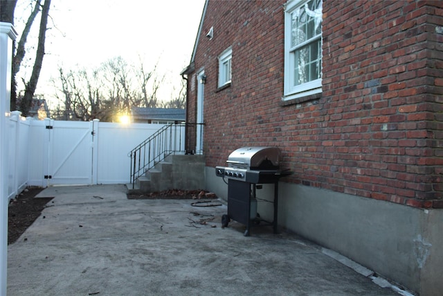 view of side of property featuring brick siding, fence, and a gate