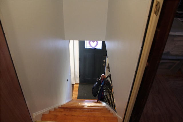 stairway featuring baseboards and wood finished floors