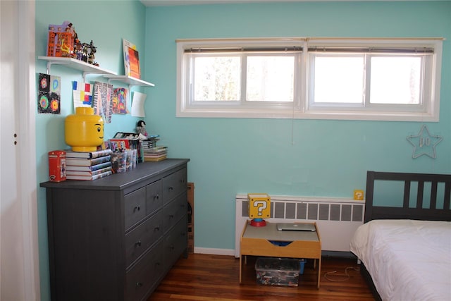 bedroom featuring radiator heating unit, baseboards, and dark wood-type flooring