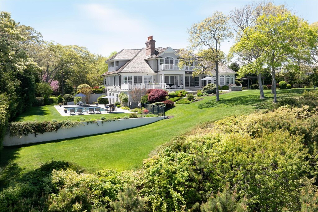 3745 Nassau Point Rd, Cutchogue, NY 11935 - rear view of property featuring a yard, a pool, a balcony, and a chimney