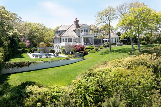 3745 Nassau Point Rd, Cutchogue, NY 11935 - rear view of property featuring a yard, a pool, a balcony, and a chimney