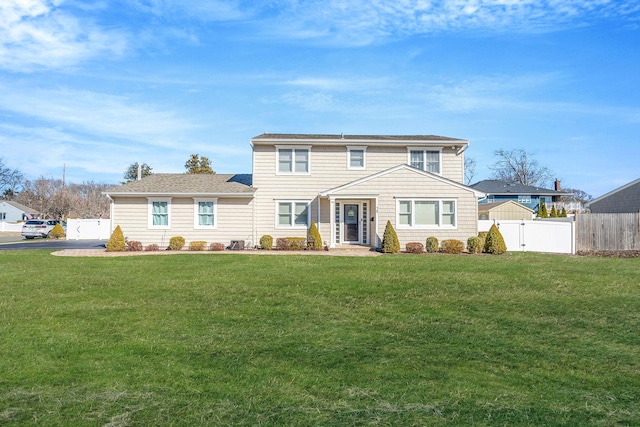 traditional home with a front yard, a gate, and fence