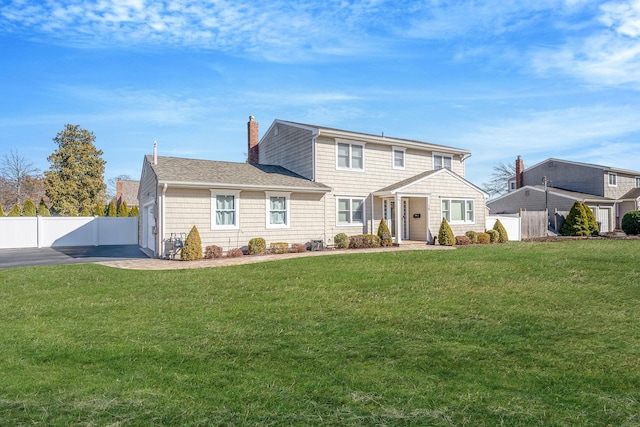 view of front of home featuring a front lawn, a chimney, a shingled roof, and fence