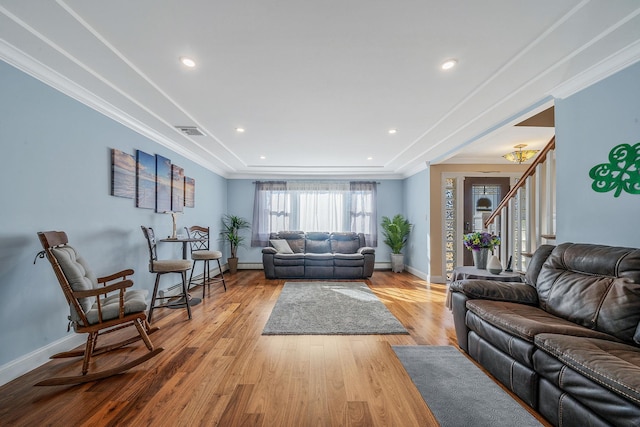 living area featuring baseboards, crown molding, visible vents, and wood finished floors