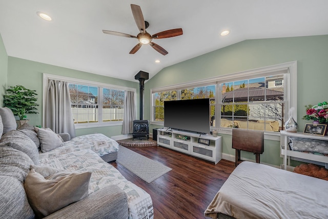 bedroom featuring lofted ceiling, ceiling fan, recessed lighting, wood finished floors, and a wood stove