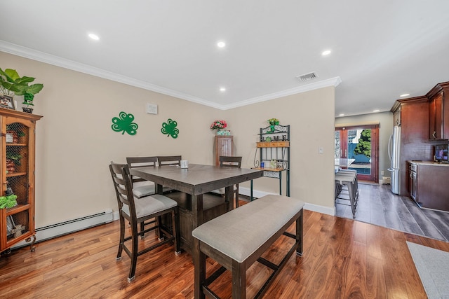 dining room featuring crown molding, light wood finished floors, recessed lighting, visible vents, and a baseboard heating unit