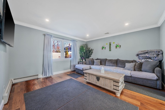 living room with visible vents, baseboard heating, ornamental molding, a baseboard heating unit, and wood finished floors