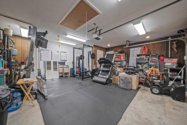 garage with a garage door opener and wooden walls