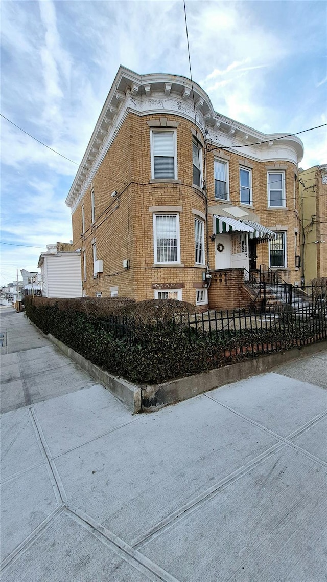 exterior space with a fenced front yard and brick siding