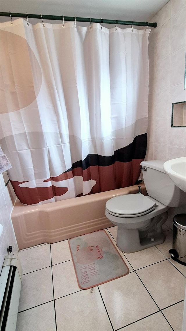 bathroom with toilet, tile patterned flooring, shower / bath combo with shower curtain, and tile walls