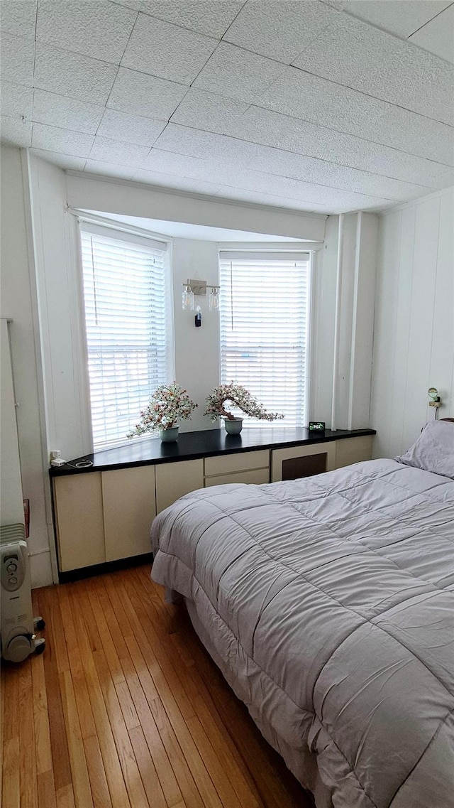 bedroom featuring multiple windows and light wood-style flooring